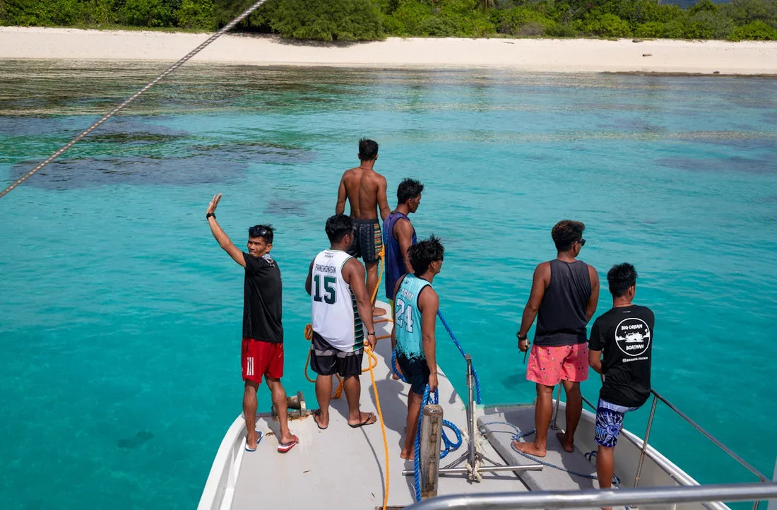 Group of people on a boat in clear blue ocean