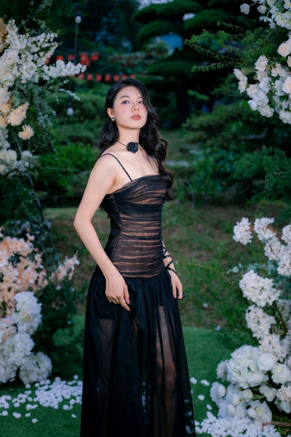 Young woman in elegant black dress in garden
