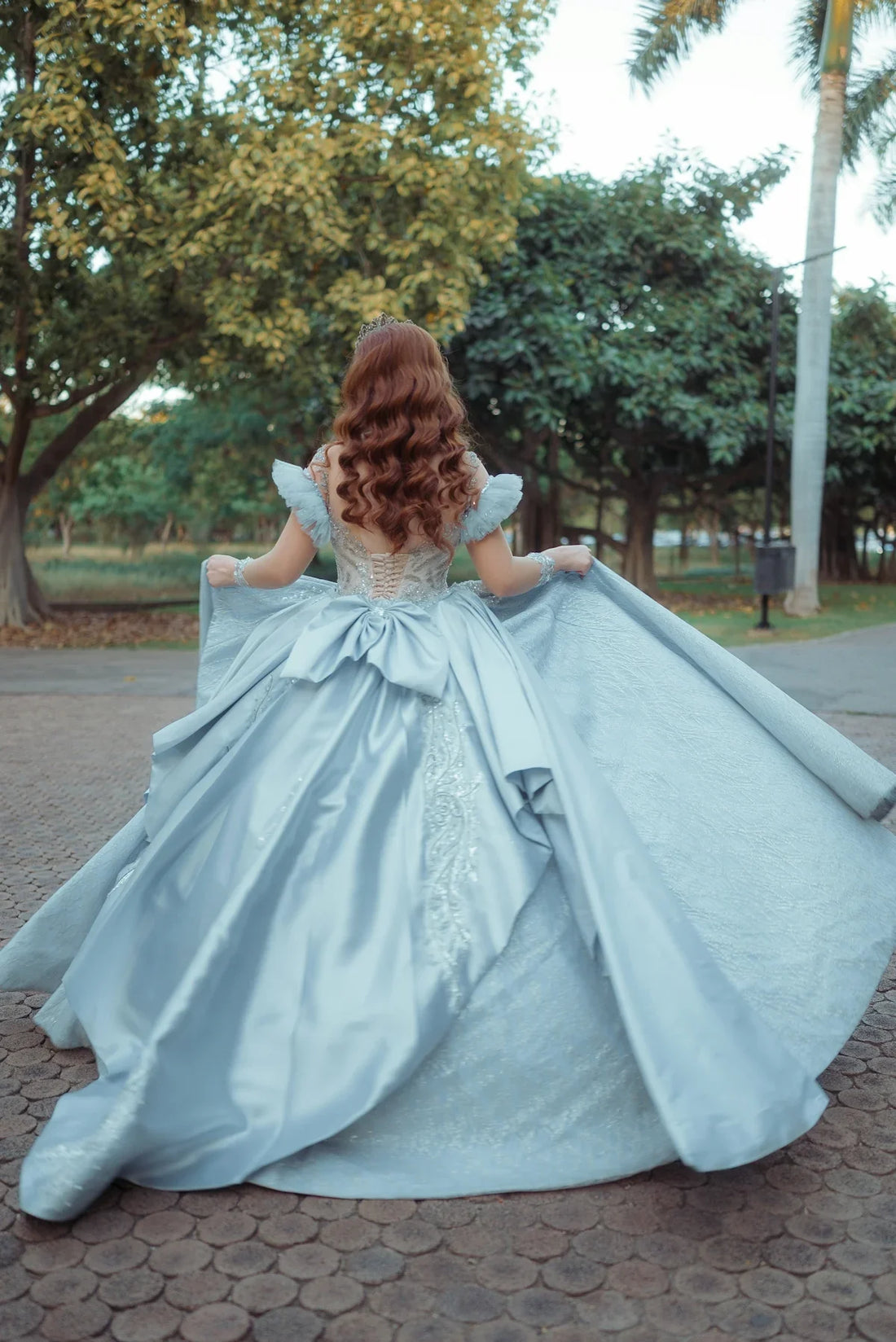 Woman in elegant blue gown with flowing train
