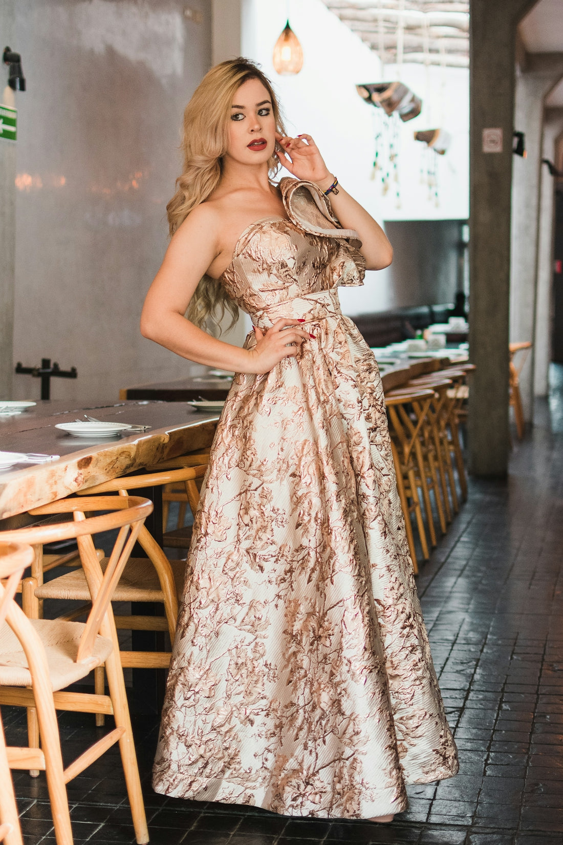 Woman in elegant patterned dress posing in restaurant