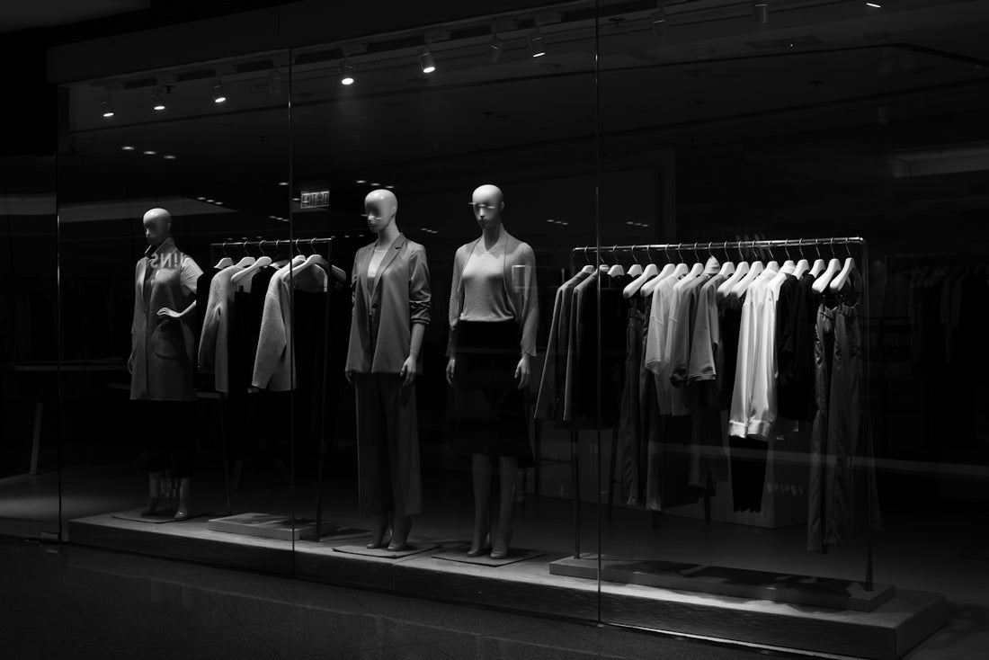 Mannequins display clothing in a dimly lit store.
