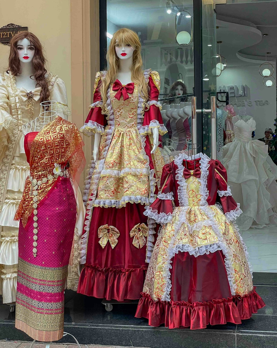 Mannequins display ornate red and gold dresses.