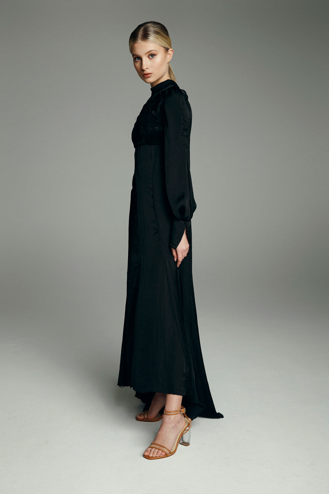Elegant woman posing in a long black dress.