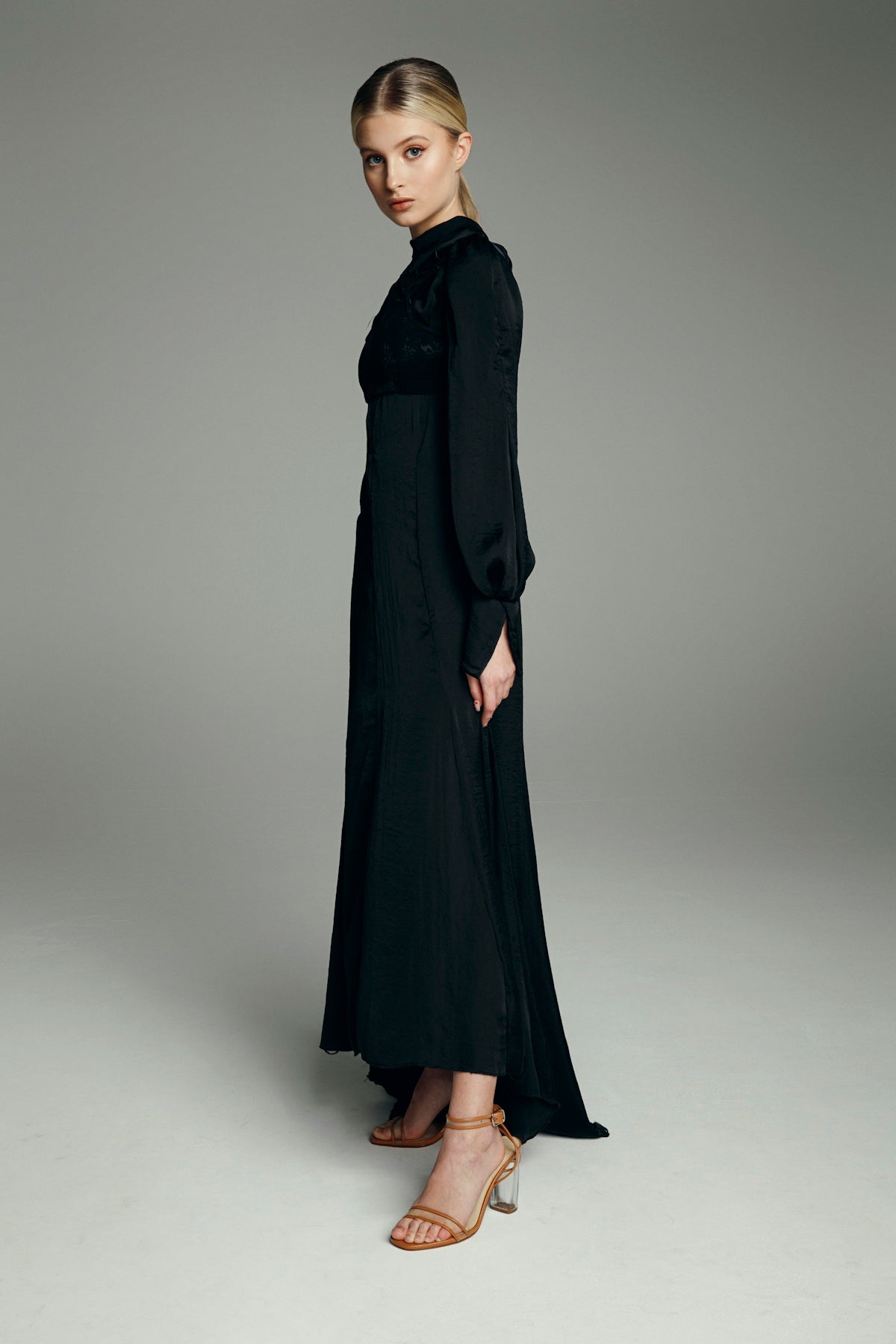 Elegant woman posing in a long black dress.