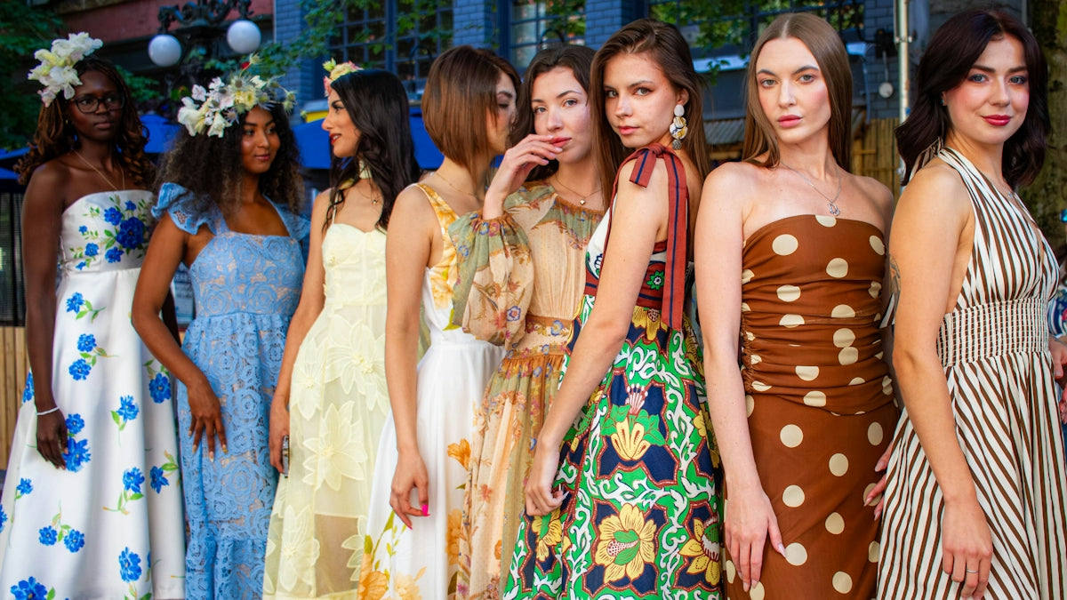 Eight women in colorful dresses standing together