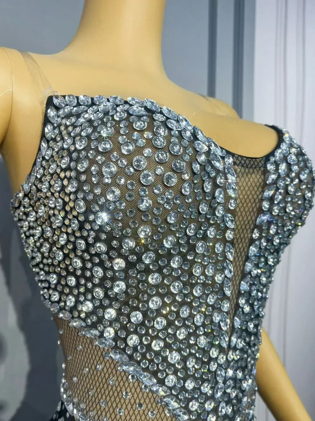 Mannequin wearing a black dress with silver beading against a neutral background